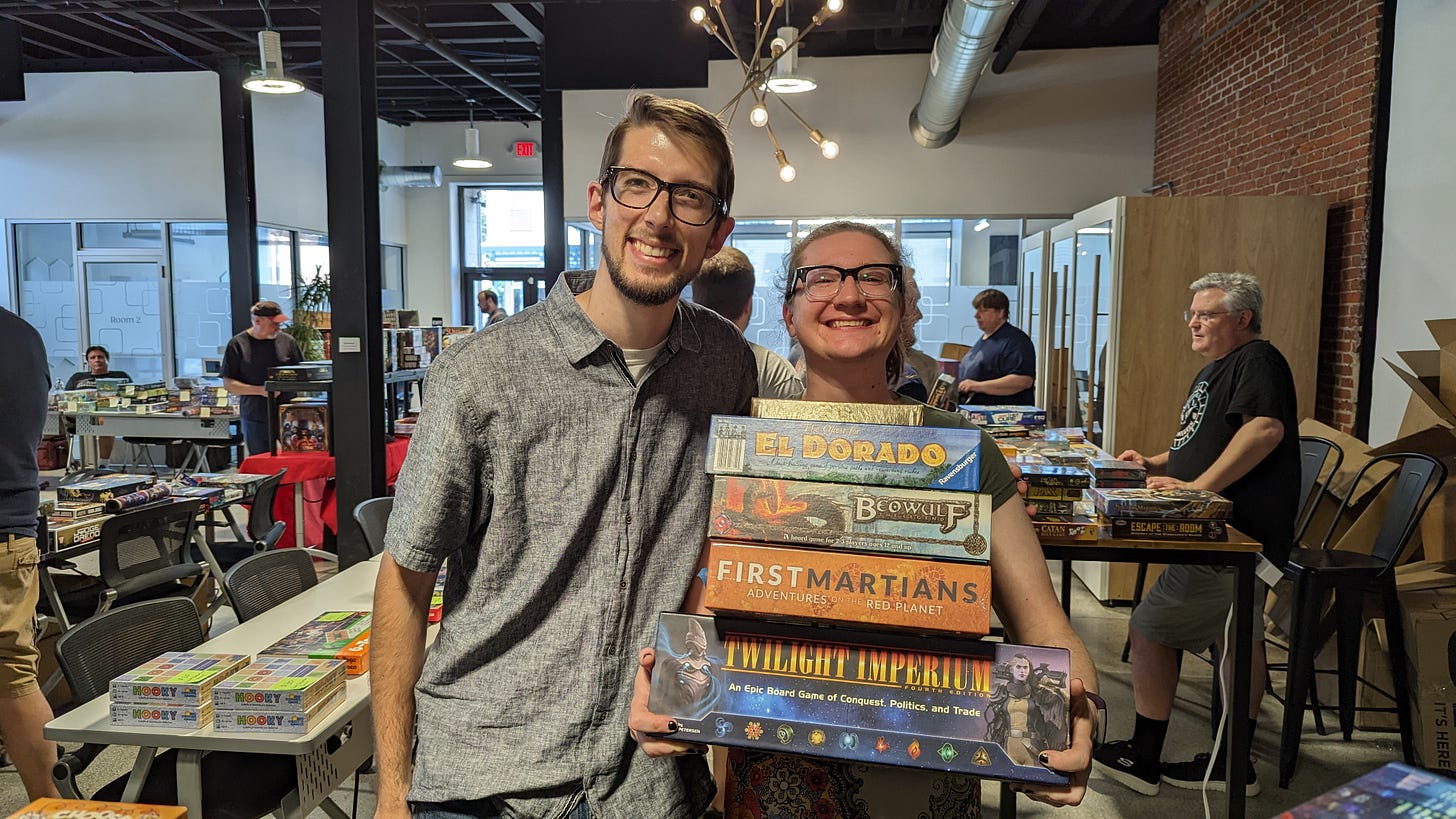 young couple happily holding board games from the sale. young couple happily holding board games from the sale.
