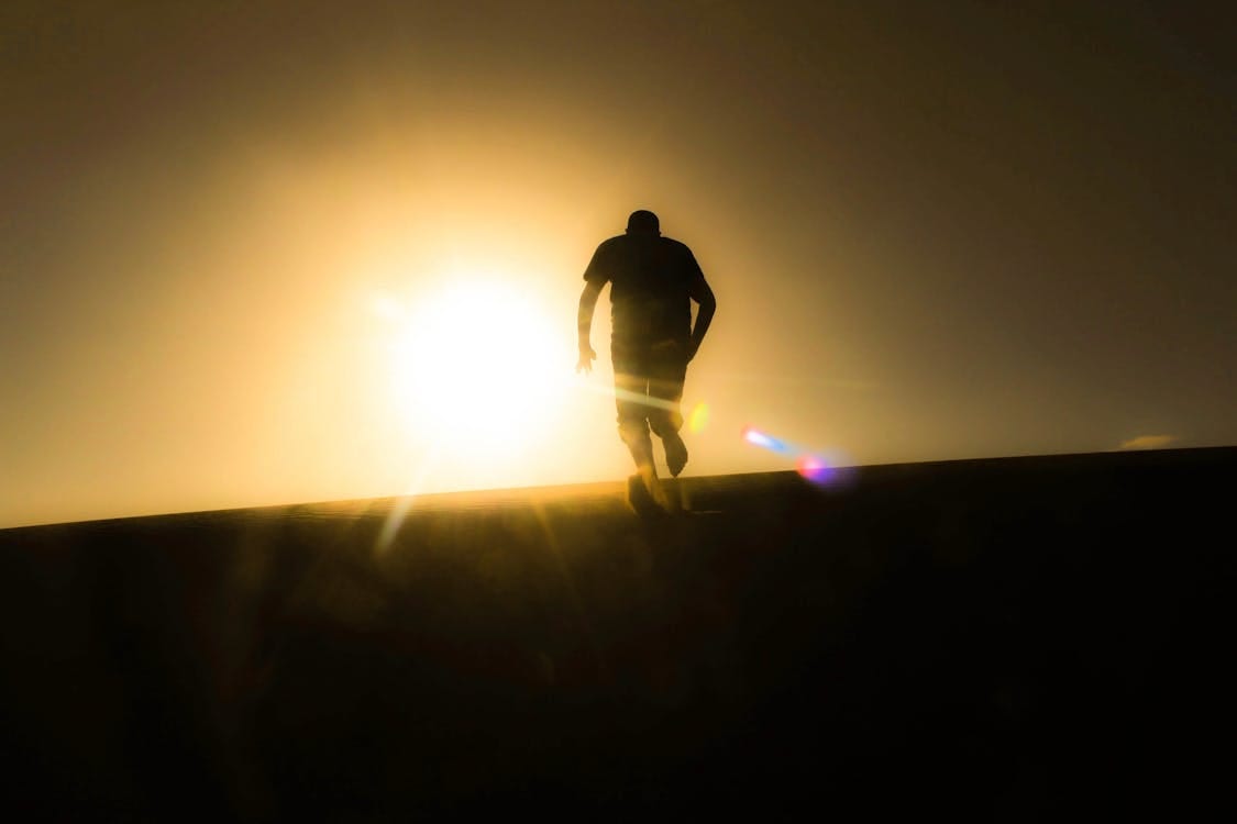 Free Silhouette of a man running uphill against a bright desert sunrise, capturing a sense of solitude and determination. Stock Photo Free Silhouette of a man running uphill against a bright desert sunrise, capturing a sense of solitude and determination. Stock Photo