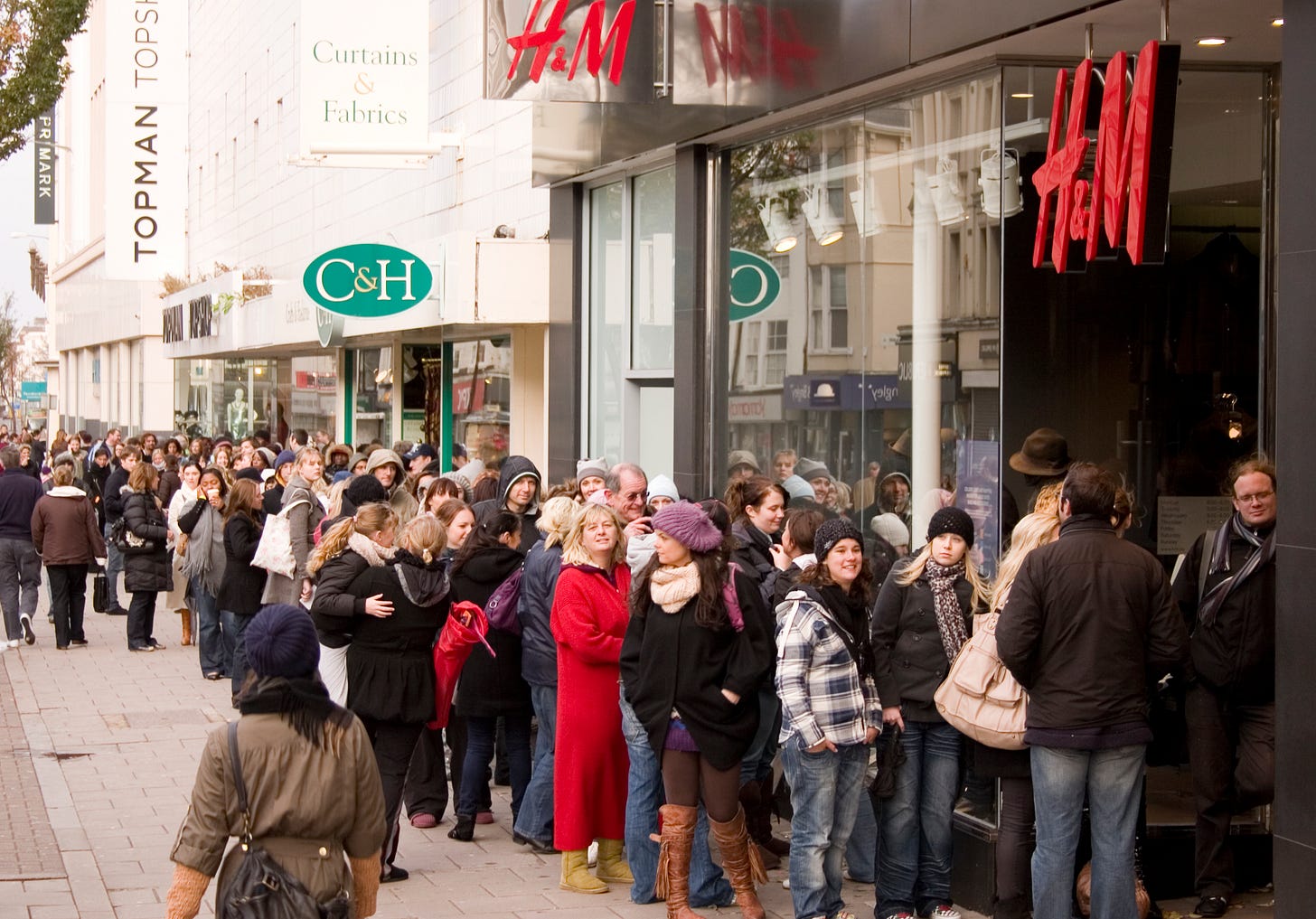 A long line of shoppers outside an H&M store for the Jimmy Choo x H&M launch in Brighton, 2009. A long line of shoppers outside an H&M store for the Jimmy Choo x H&M launch in Brighton, 2009.