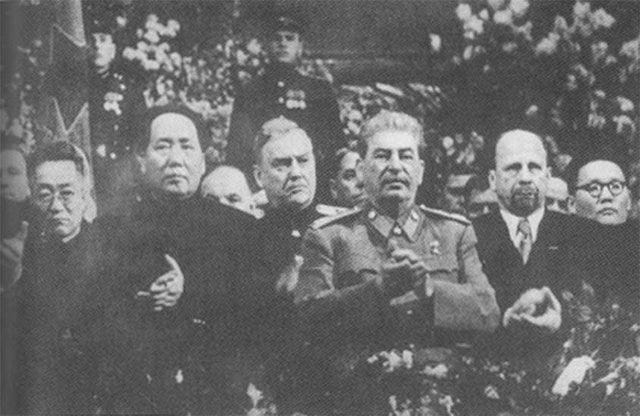 Black and white photograph showing a group of standing people including Mao Zedong and Joseph Stalin