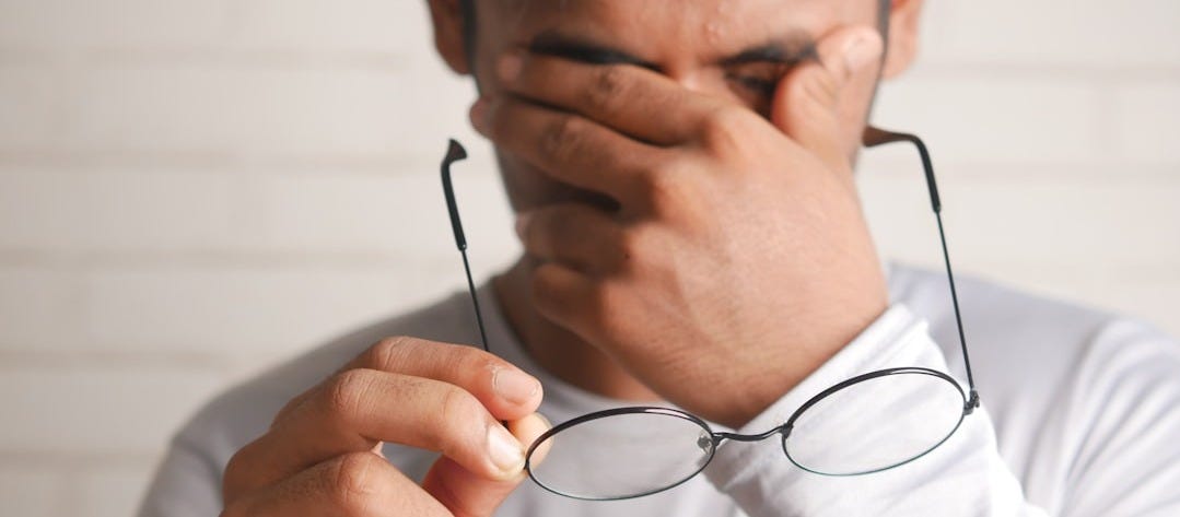 a man holding a pair of glasses up to his face a man holding a pair of glasses up to his face