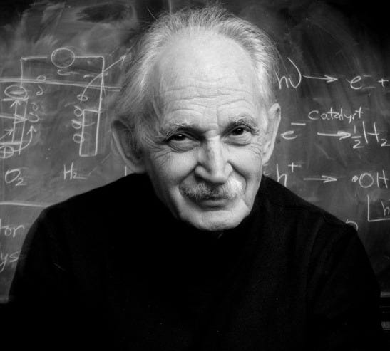 Black and white portrait of Professor Allen J. Bard in front of a blackboard