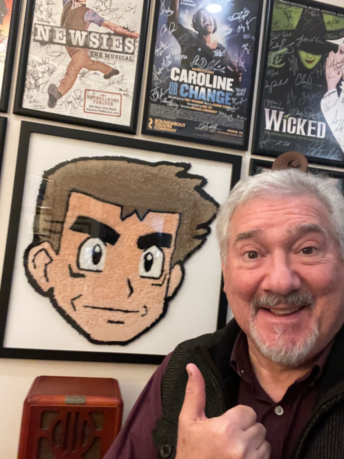 Stuart with his Professor Oak “Rug Face” that he received from a fan. He had the rug professionally framed, and it now hangs in his office at his home Stuart with his Professor Oak “Rug Face” that he received from a fan. He had the rug professionally framed, and it now hangs in his office at his home