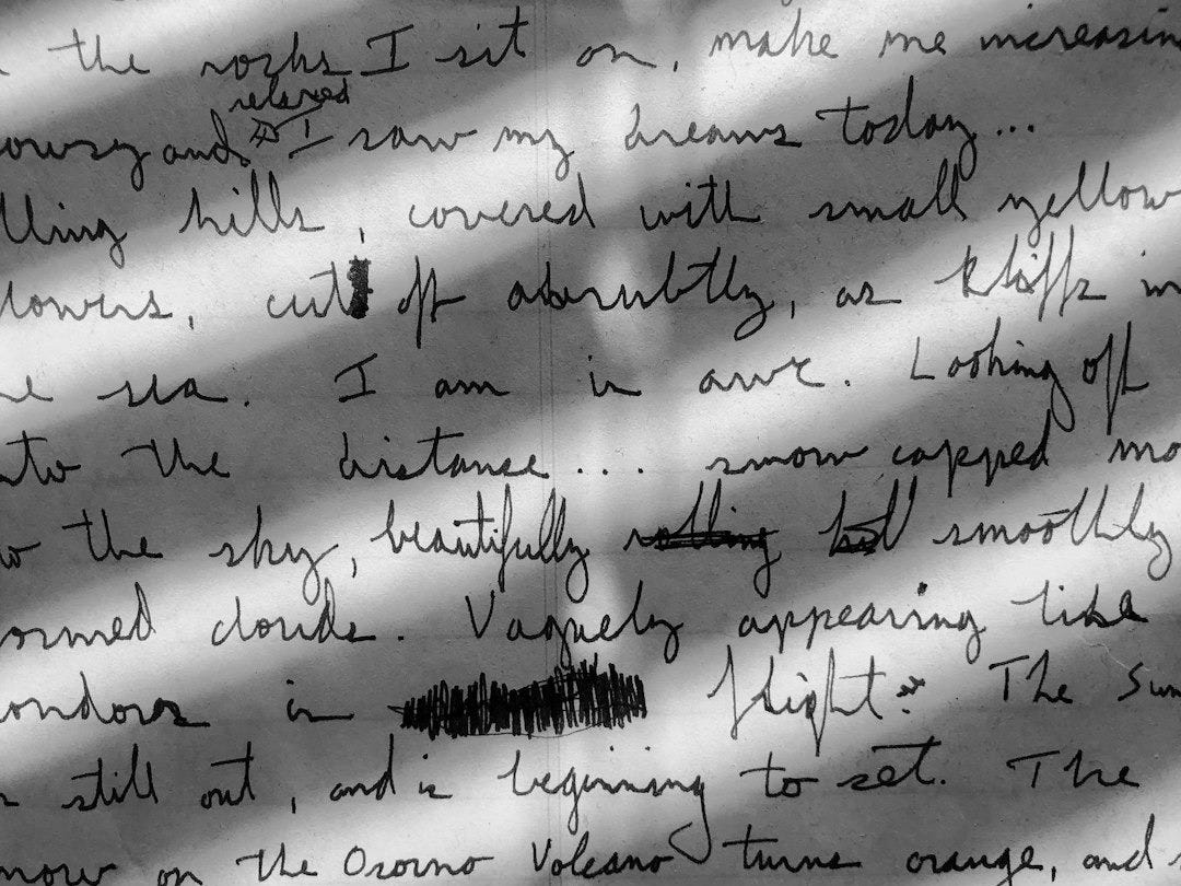 Handwritten cursive text on paper with diagonal shadows cast across the page