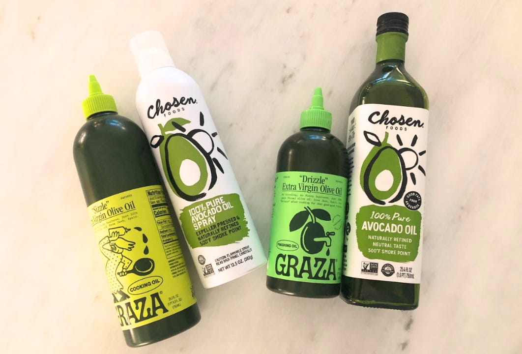A set of olive and avocado oils arranged on a light surface, showing clean, minimal packaging. Type Won Life™. A set of olive and avocado oils arranged on a light surface, showing clean, minimal packaging. Type Won Life™.