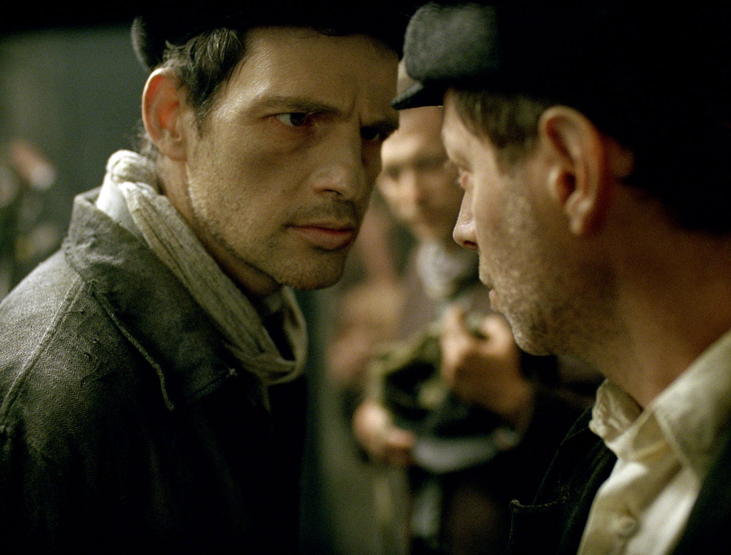 Close up of two thin ragged looking men staring at each other; background blurred. setting is a concentration camp Close up of two thin ragged looking men staring at each other; background blurred. setting is a concentration camp