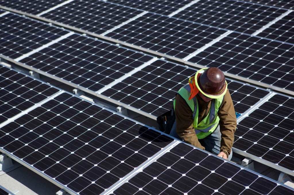 A man inspects solar panels. A man inspects solar panels.