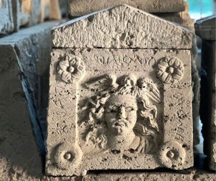 High-relief carving of Medusa on the side of Etruscan urn, ca. 3rd century B.C. Photo courtesy Ipogeo dei Volumni e Necropoli del Palazzone.