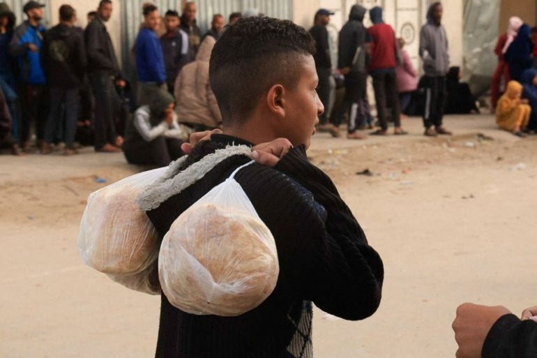 A youth carries bags with bread