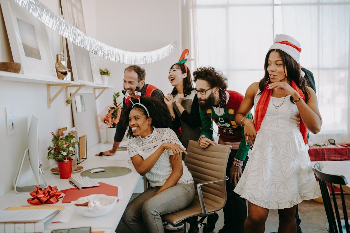 Free Diverse colleagues enjoy a festive Christmas party in the office, bonding and celebrating together. Stock Photo