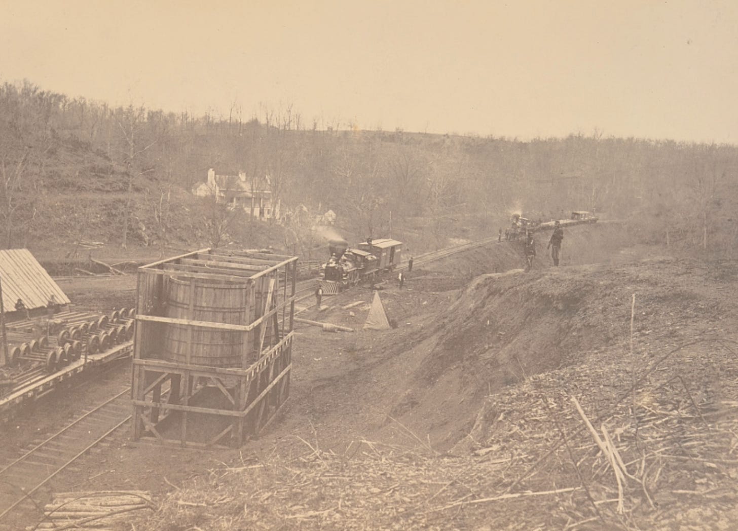 Albumen photograph from 1863–1865 showing two steam locomotives approaching Union Mills Station on the Orange & Alexandria Railroad in Clifton, Virginia, with two soldiers standing guard on the bank at right. Albumen photograph from 1863–1865 showing two steam locomotives approaching Union Mills Station on the Orange & Alexandria Railroad in Clifton, Virginia, with two soldiers standing guard on the bank at right.