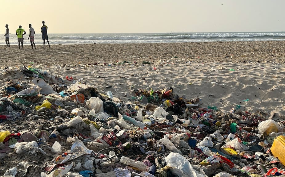 Boys standing on the beach shore backing a heap of plastic waste. Boys standing on the beach shore backing a heap of plastic waste.