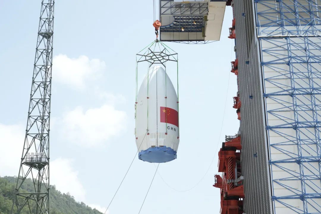The Long March 2D’s 4.2-meter diameter composite fairing being lifted atop of the vehicle.