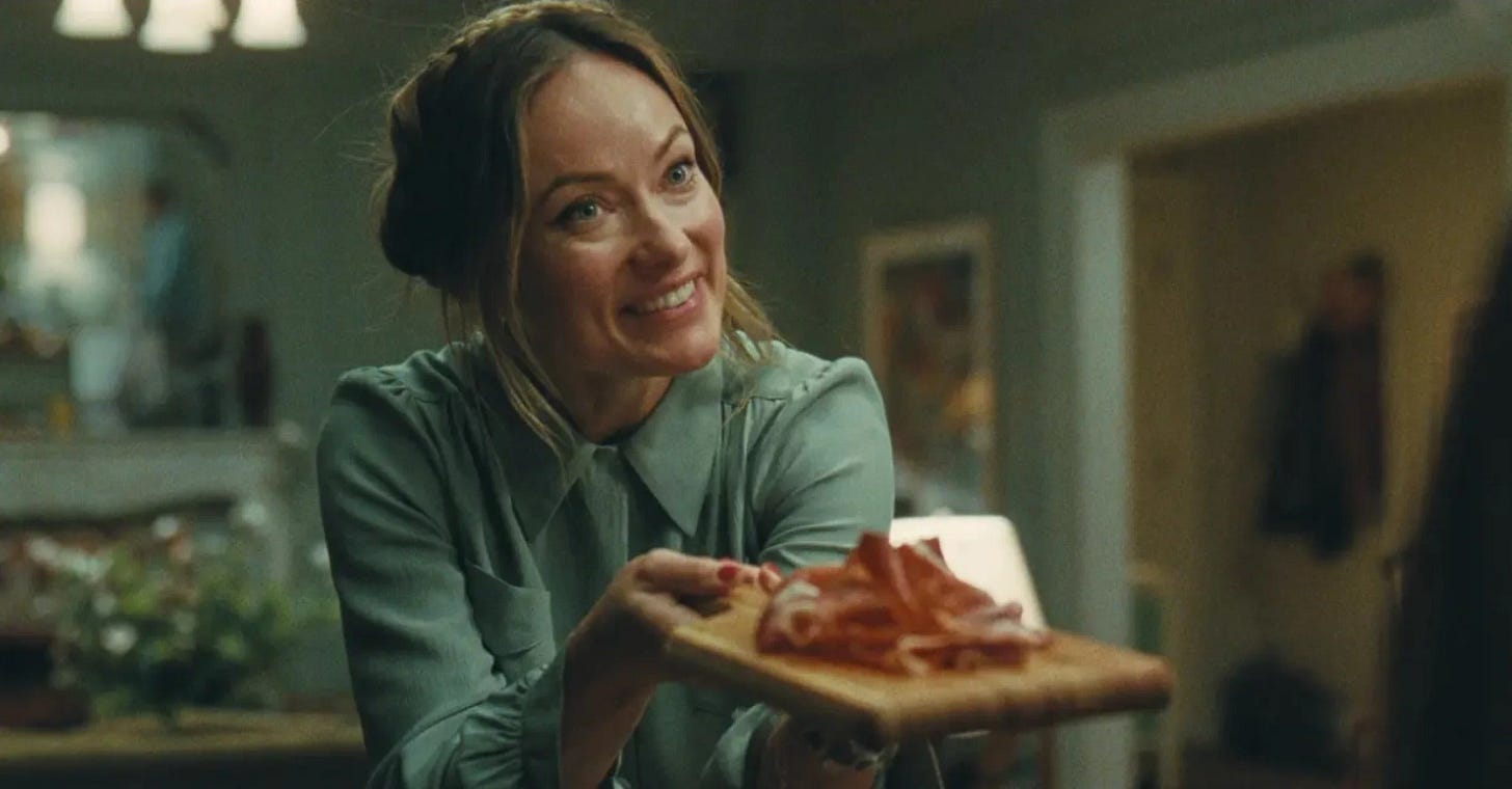 Olivia Wilde holding a platter of either jamon or prosciutto and offering it somewhat desperately Olivia Wilde holding a platter of either jamon or prosciutto and offering it somewhat desperately