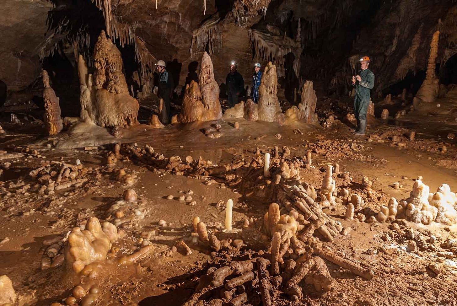 Structures underground at Bruniquel Cave with caver in background Structures underground at Bruniquel Cave with caver in background