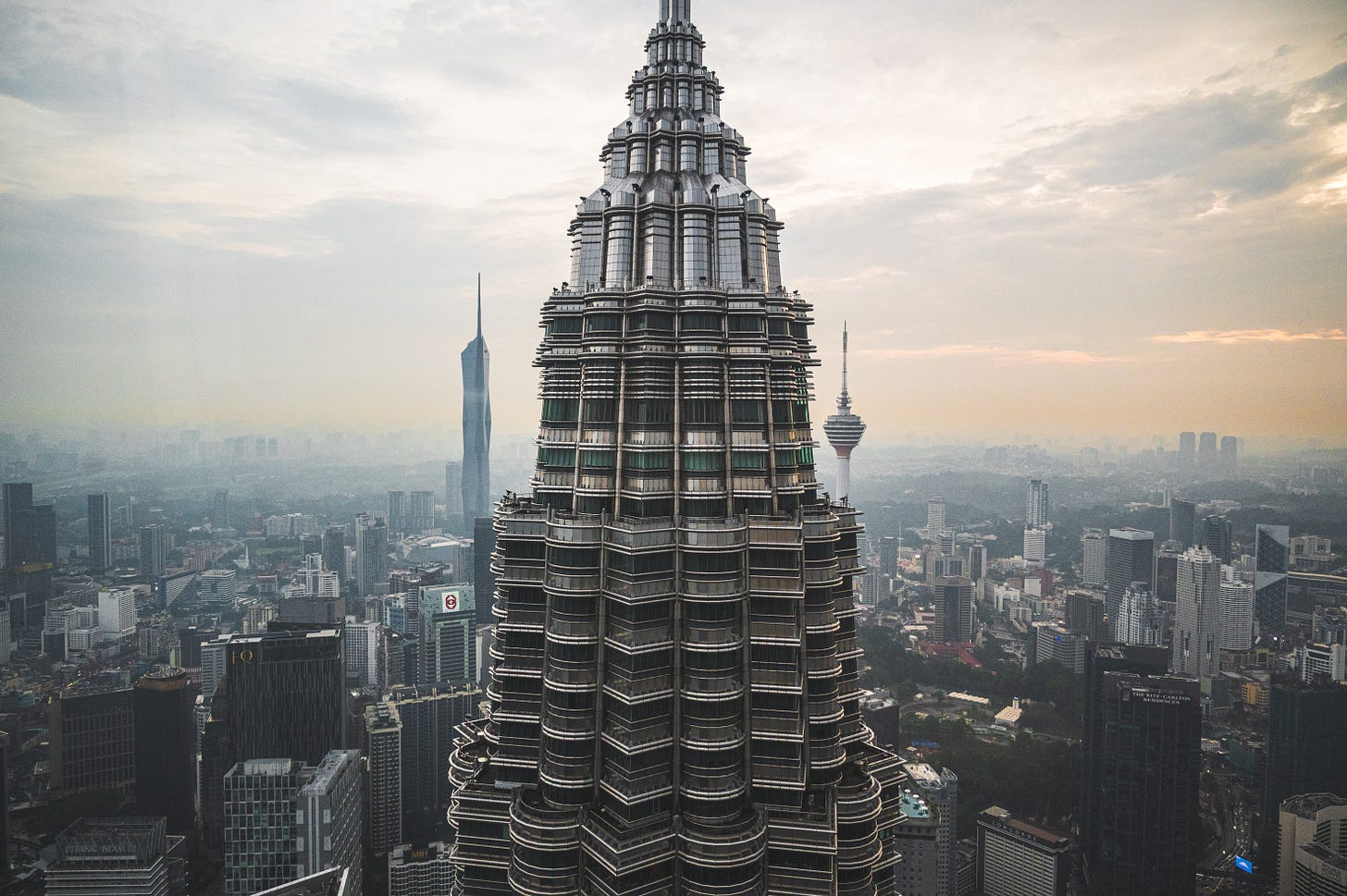 The view of one of the Petronas Twin Towers in Kuala Lumpur, with two skyscrapers visible on the skyline behind it. The view of one of the Petronas Twin Towers in Kuala Lumpur, with two skyscrapers visible on the skyline behind it.