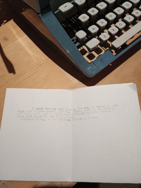 Desk with wooden chair and typewriter in mock office; Annette typing;corner of typewriter with Annette's typed note