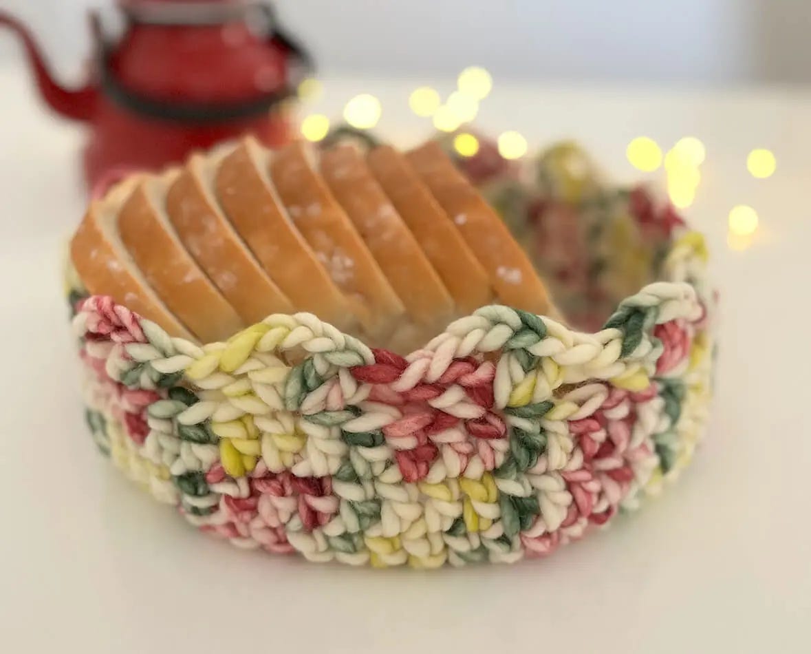 knitted basked with bread, and a kettle in the background