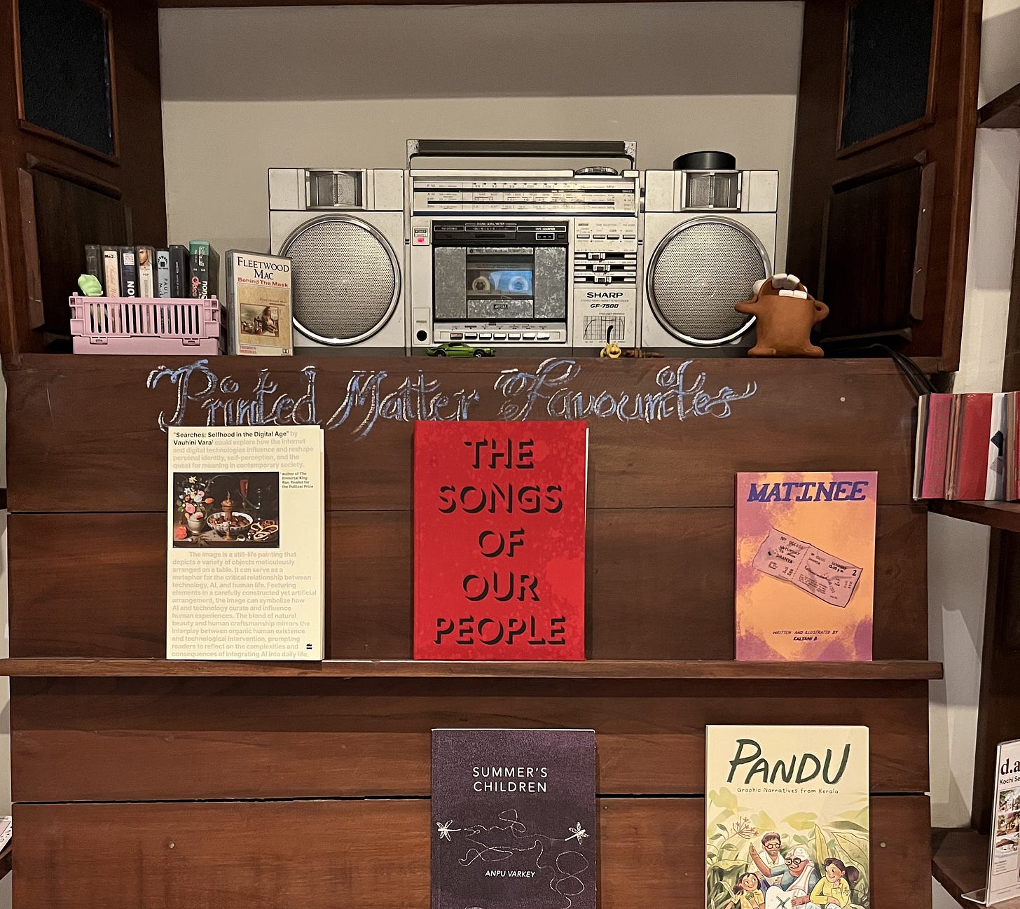 A shelf of Printed Matter bookshop, stereo on the top shelf, recommended books on the lower shelves A shelf of Printed Matter bookshop, stereo on the top shelf, recommended books on the lower shelves