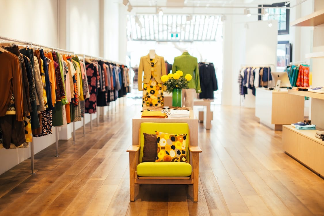 Free Interior of modern fashion store with stylish colorful clothes handing on rack in daytime Stock Photo