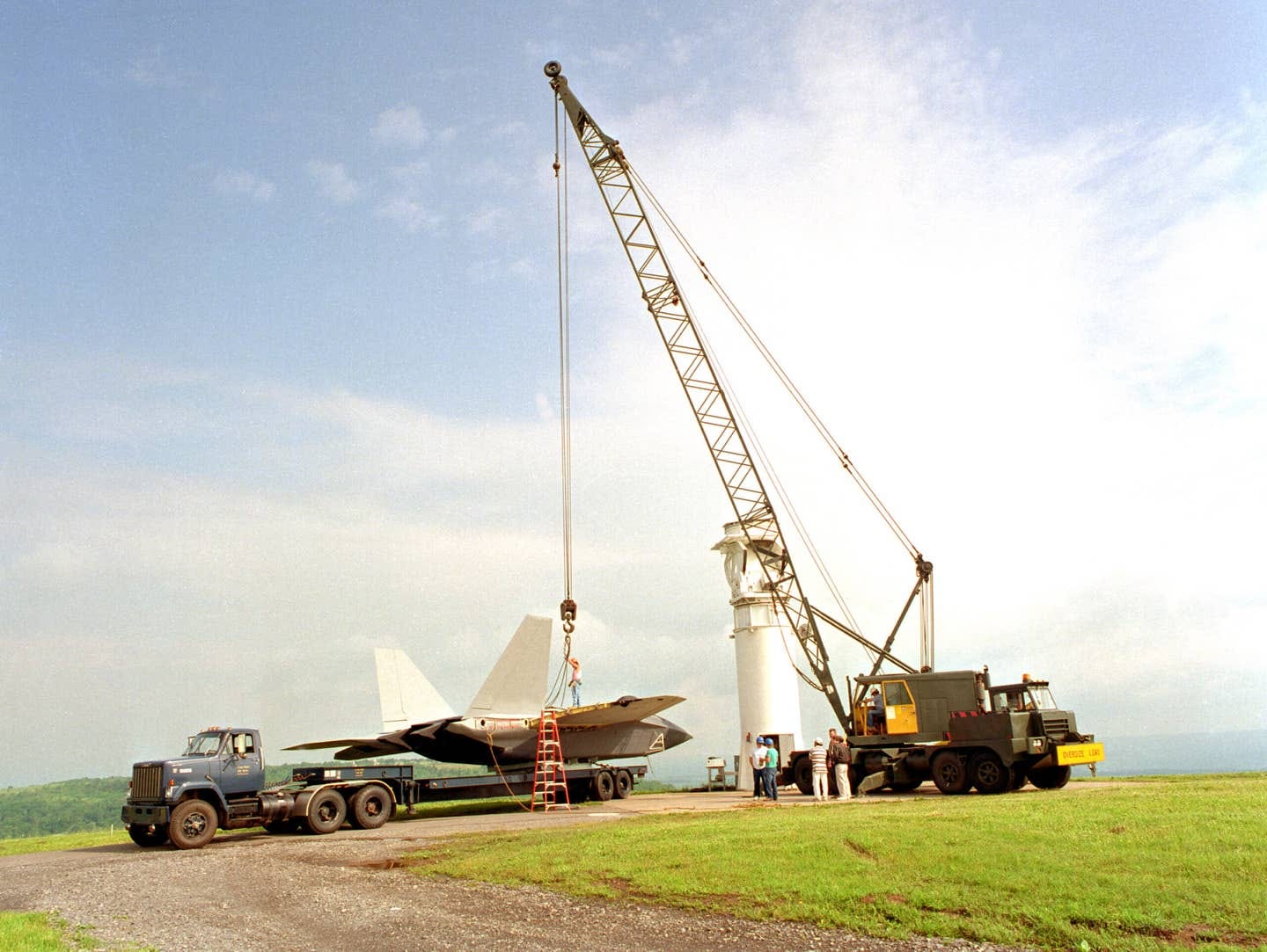 A crew assigned to Rome Laboratory's Newport, NY test site prepares to hoist a modified YF-22 airframe to a pedestal for antenna measurement tests, June 1994. During initial testing, over 400,000 antenna measurements will be taken. <em>National Archives</em>