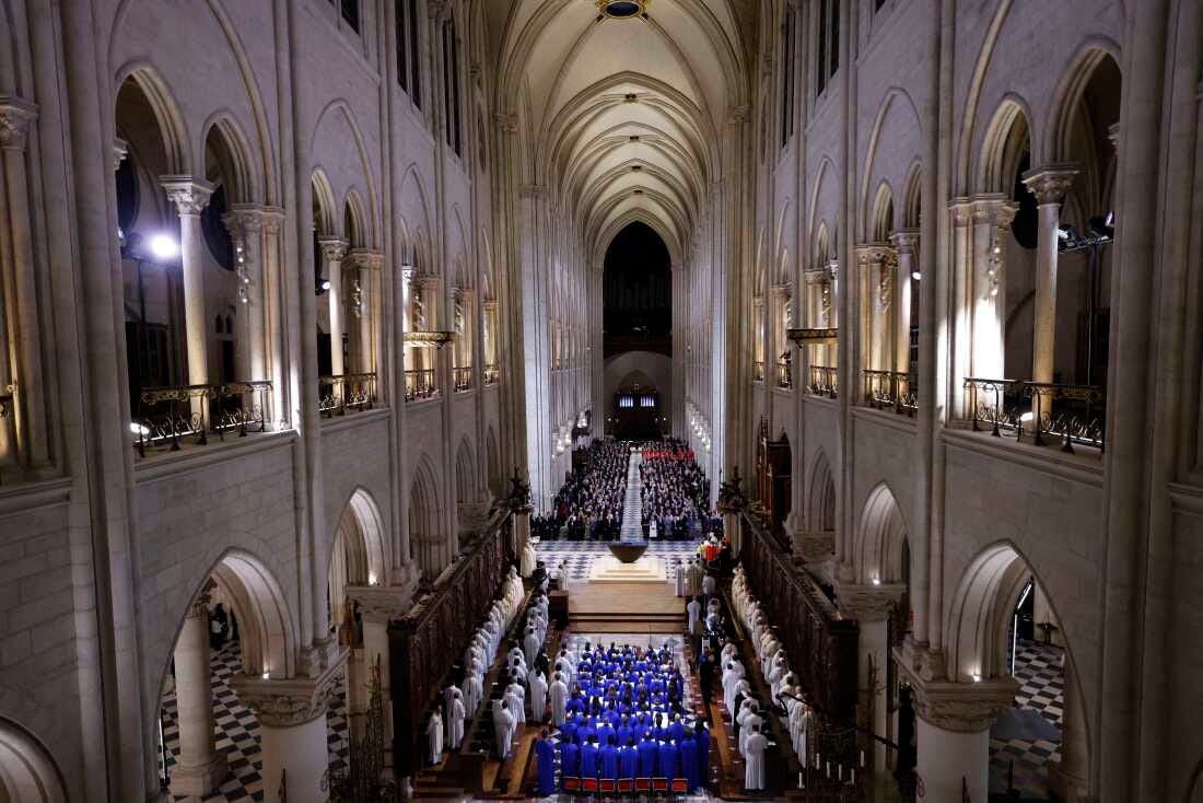 The choir, clergy and guests stand as they sing during a ceremony to mark the reopening of the landmark Notre Dame Cathedral, in central Paris, on Saturday.