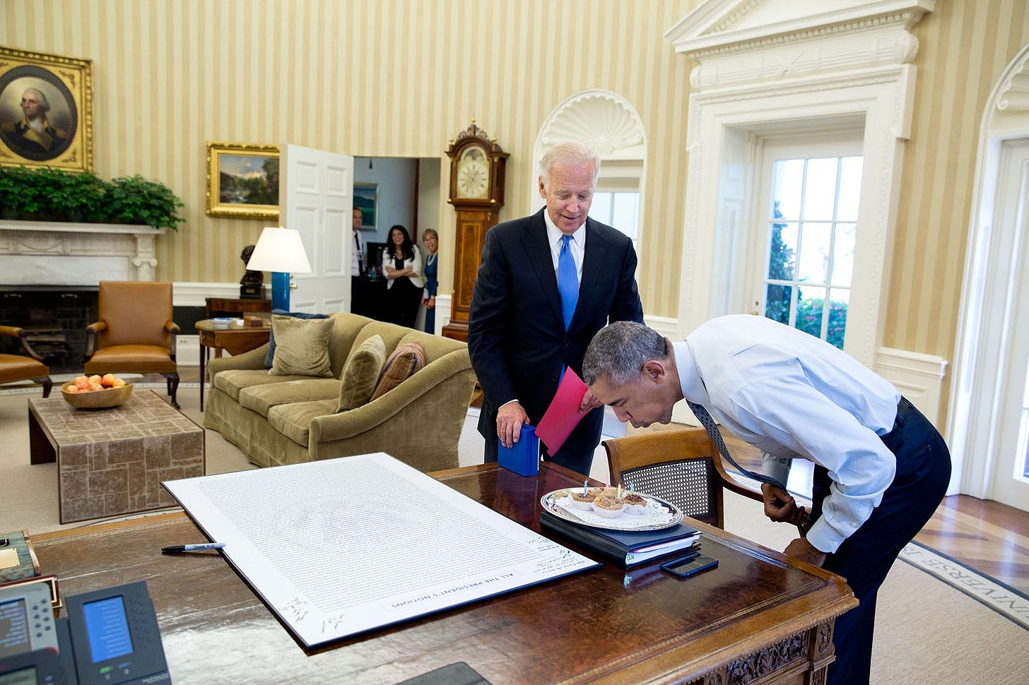 August 4, 2016: President Obama, surrounded by staff, blows out candles on birthday cupcakes, a surprise from Vice President Joe Biden. August 4, 2016: President Obama, surrounded by staff, blows out candles on birthday cupcakes, a surprise from Vice President Joe Biden.