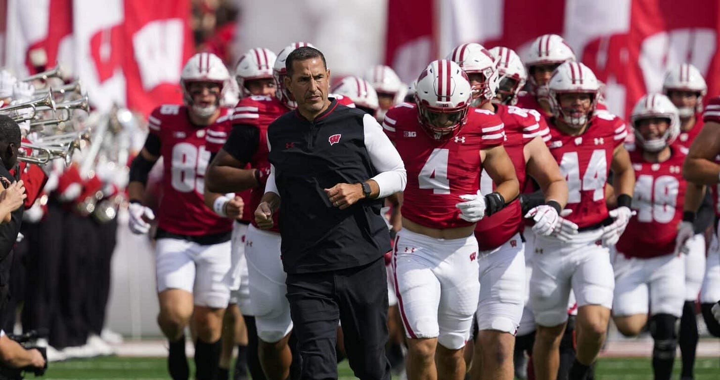 Wisconsin Badgers coach Luke Fickell runs onto the field at Camp Randall Stadium, leading the team before the start of the game.