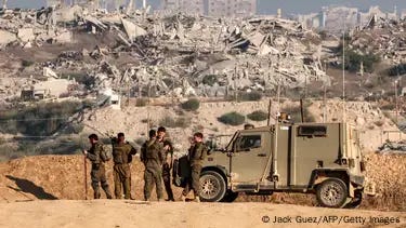 Israeli soldiers by armored vehicle along the border fence with the Gaza Strip