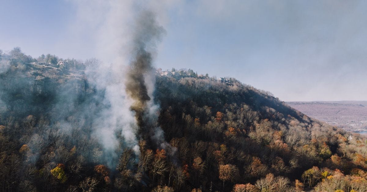 Aerial shot of smoke rising from a forest fire on a hillside in Chattanooga, Tennessee.