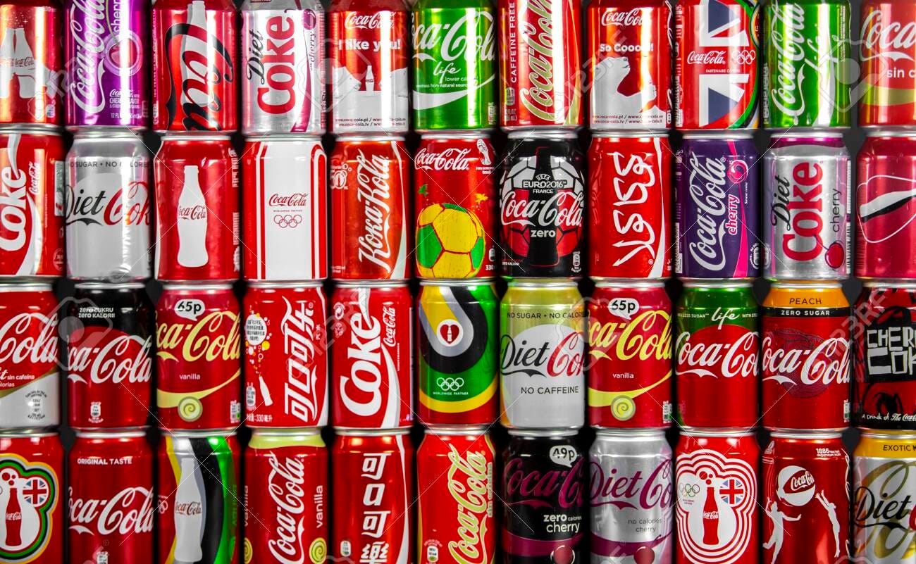 Atlanta, Georgia, USA April 4, 2020: Coca Cola Background Of Many Multi  Colored Aluminum Cans Of Different Colors, Design And Tastes With Logo In  Many Languages - Russian, Arabic, Korean. Stock Photo,