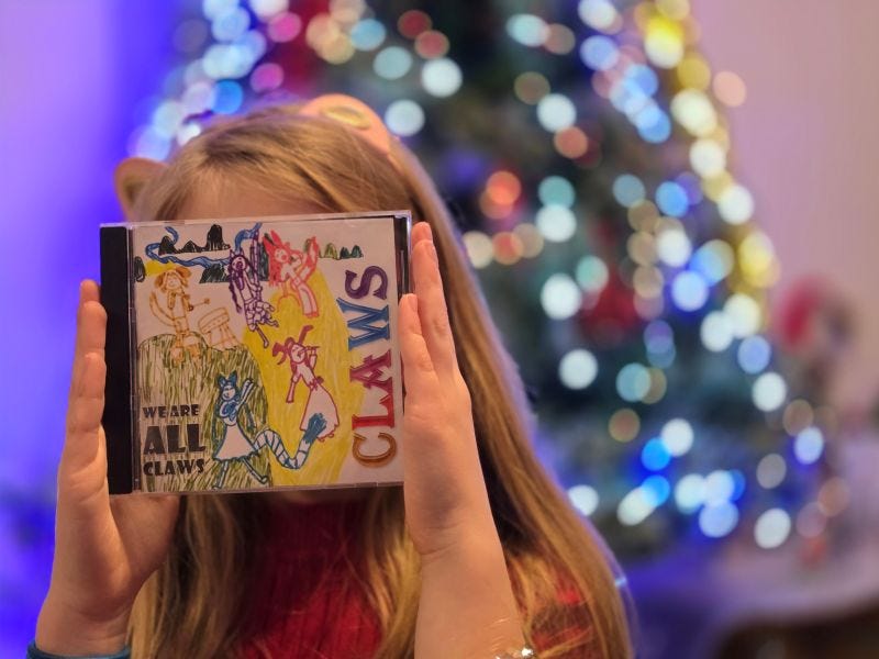 A girl holding a CLAWS CD