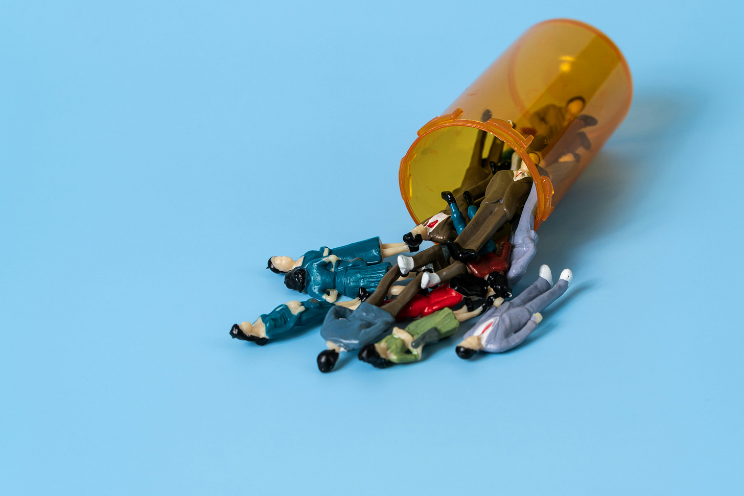 figurines falling out of a pill bottle figurines falling out of a pill bottle