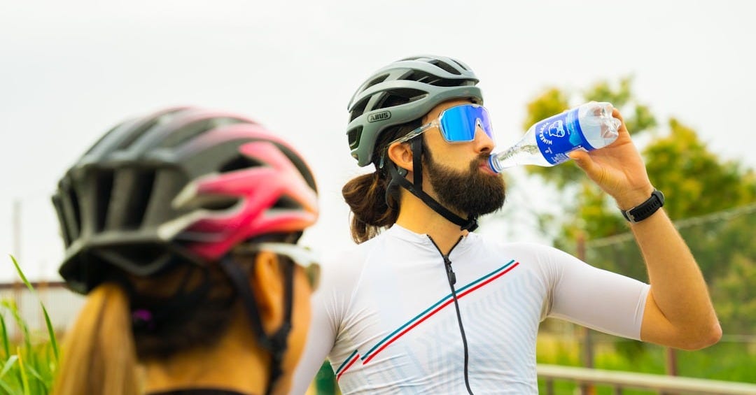 a man with a beard drinking water from a bottle