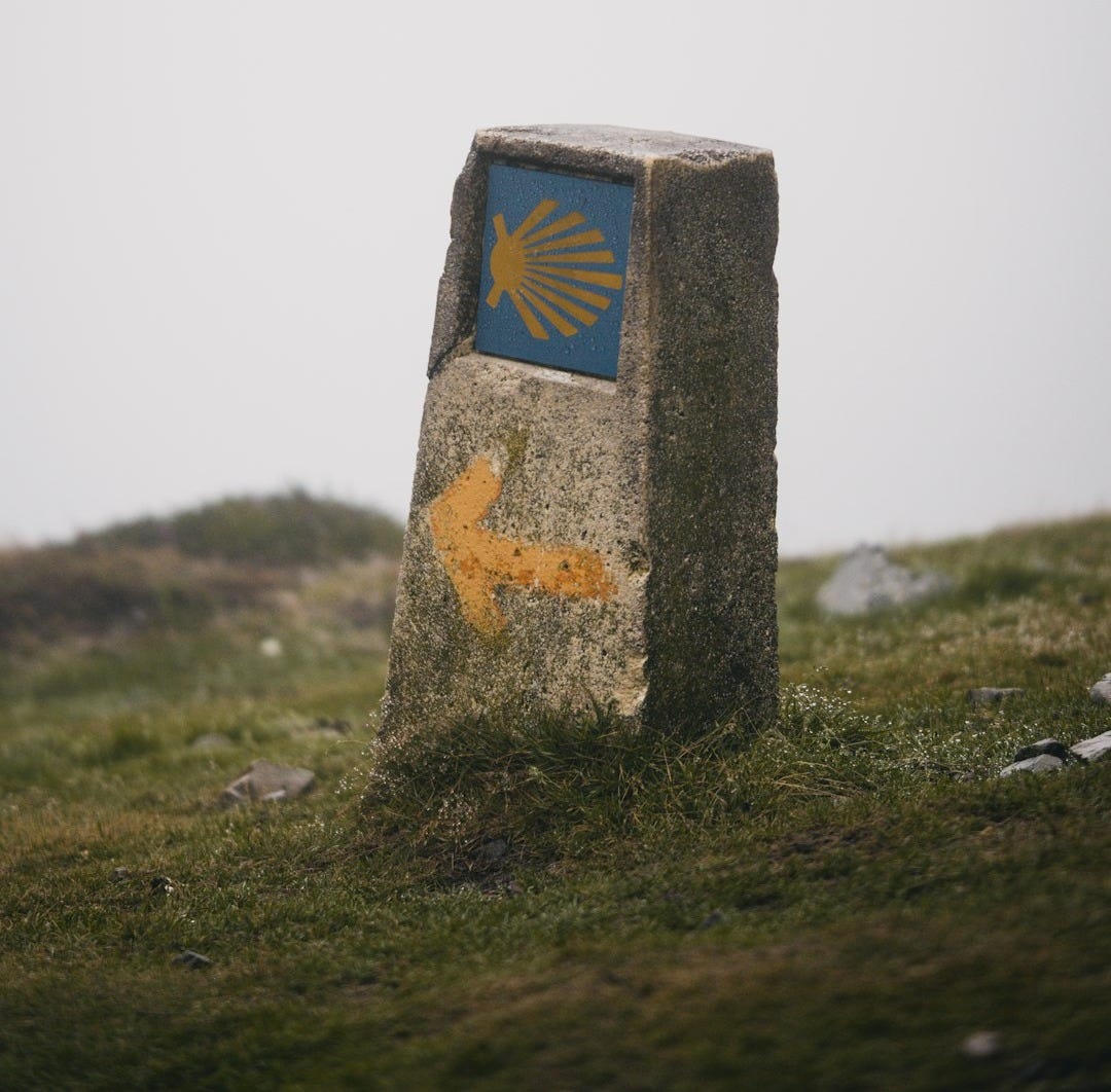 A stone marker with a blue and yellow arrow painted on it