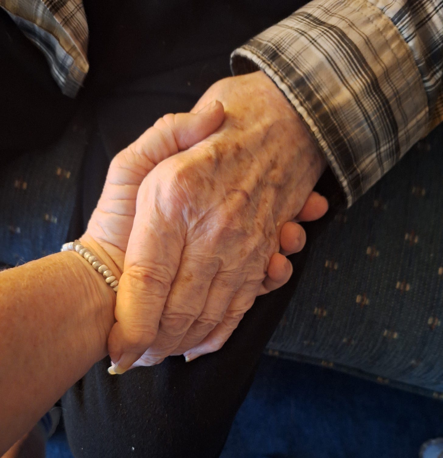 Close-up of an adult daughter’s hand gently holding her elderly father’s hand, symbolizing love, faith, and connection despite dementia. Close-up of an adult daughter’s hand gently holding her elderly father’s hand, symbolizing love, faith, and connection despite dementia.