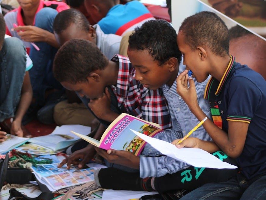 boy in blue and white plaid shirt reading book