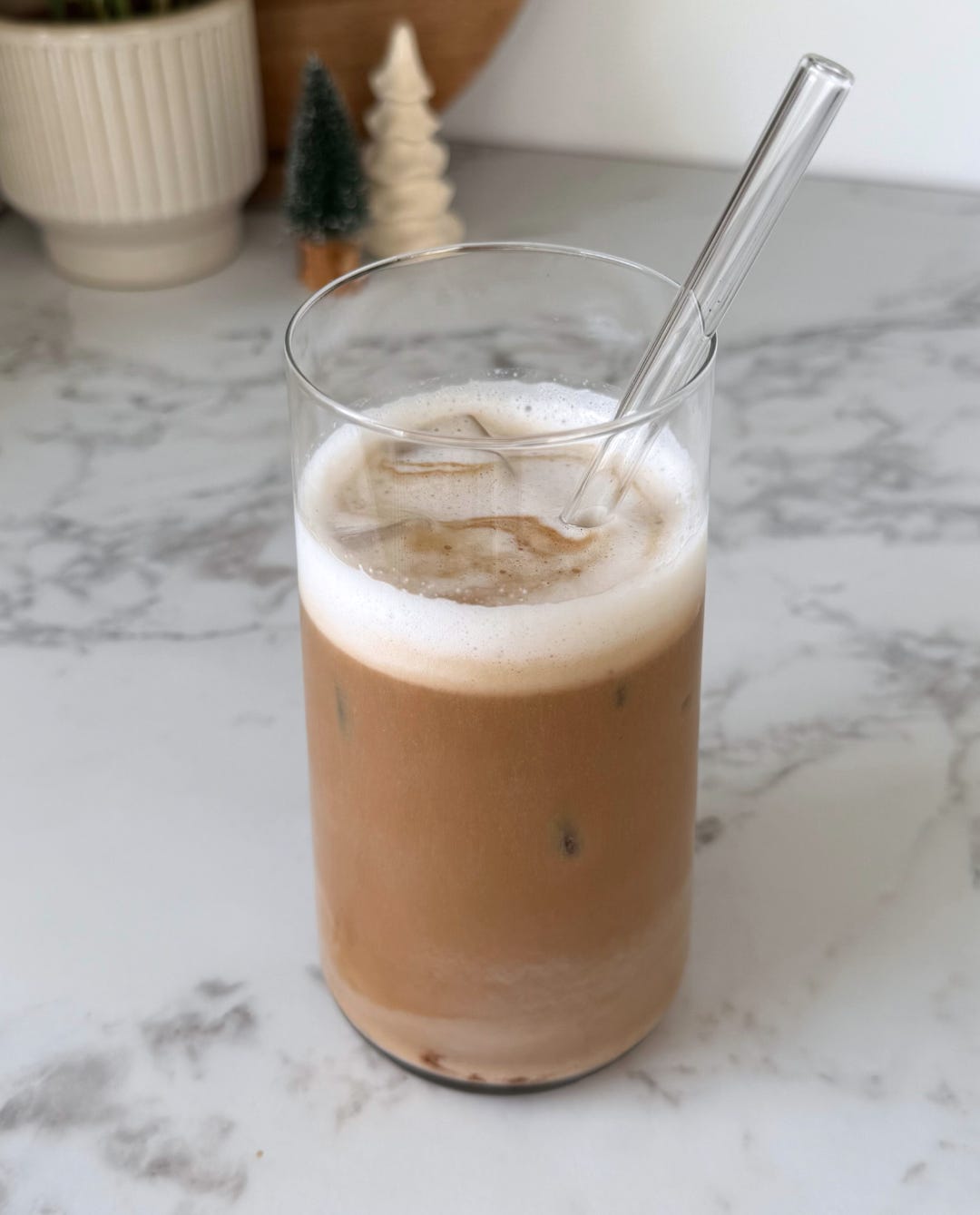 Festive iced latte in a glass, layered with espresso, almond milk, and a hint of speculoos cream, ready to sip. Festive iced latte in a glass, layered with espresso, almond milk, and a hint of speculoos cream, ready to sip.