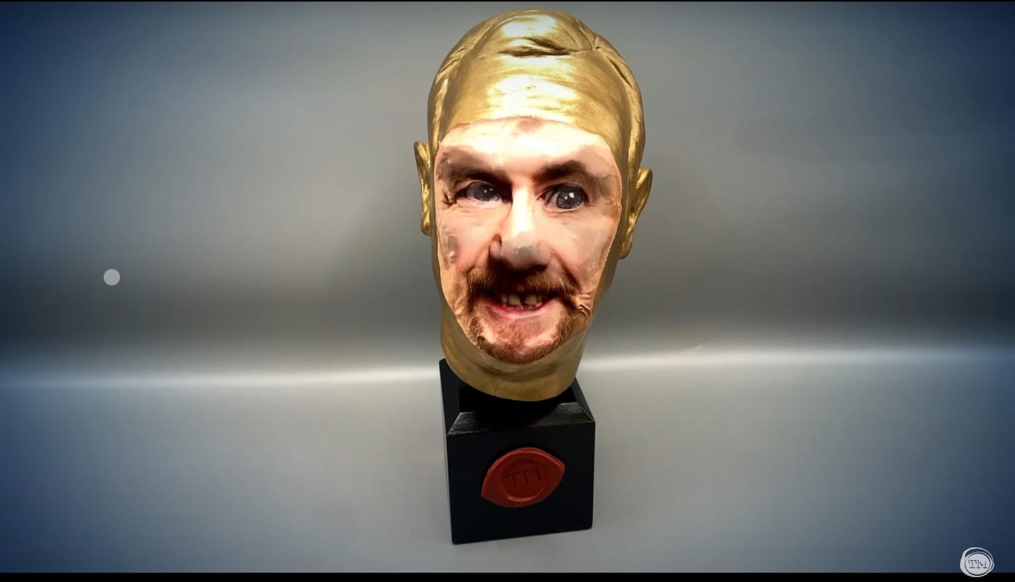 A truly terrifying imagine of a Taskmaster Golden Noggin award with Little Alex Horne’s face pasted over it.