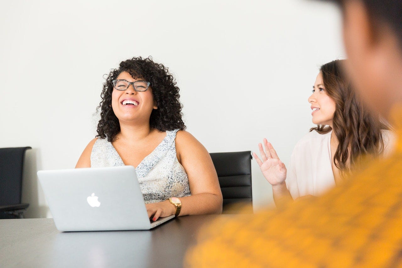 Woman laughing in work meeting Woman laughing in work meeting