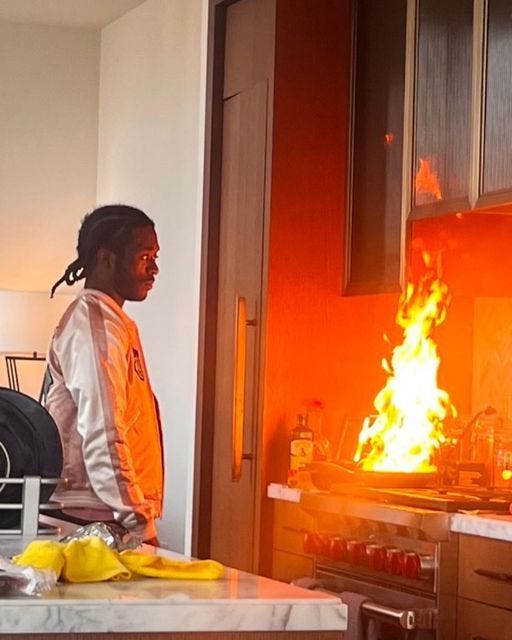 This may contain: a man standing next to a fire in a kitchen