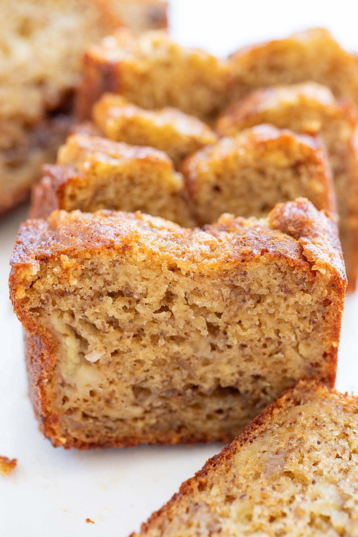 Close-up of sliced banana bread showing a moist, dense texture with visible bits of banana inside. Close-up of sliced banana bread showing a moist, dense texture with visible bits of banana inside.