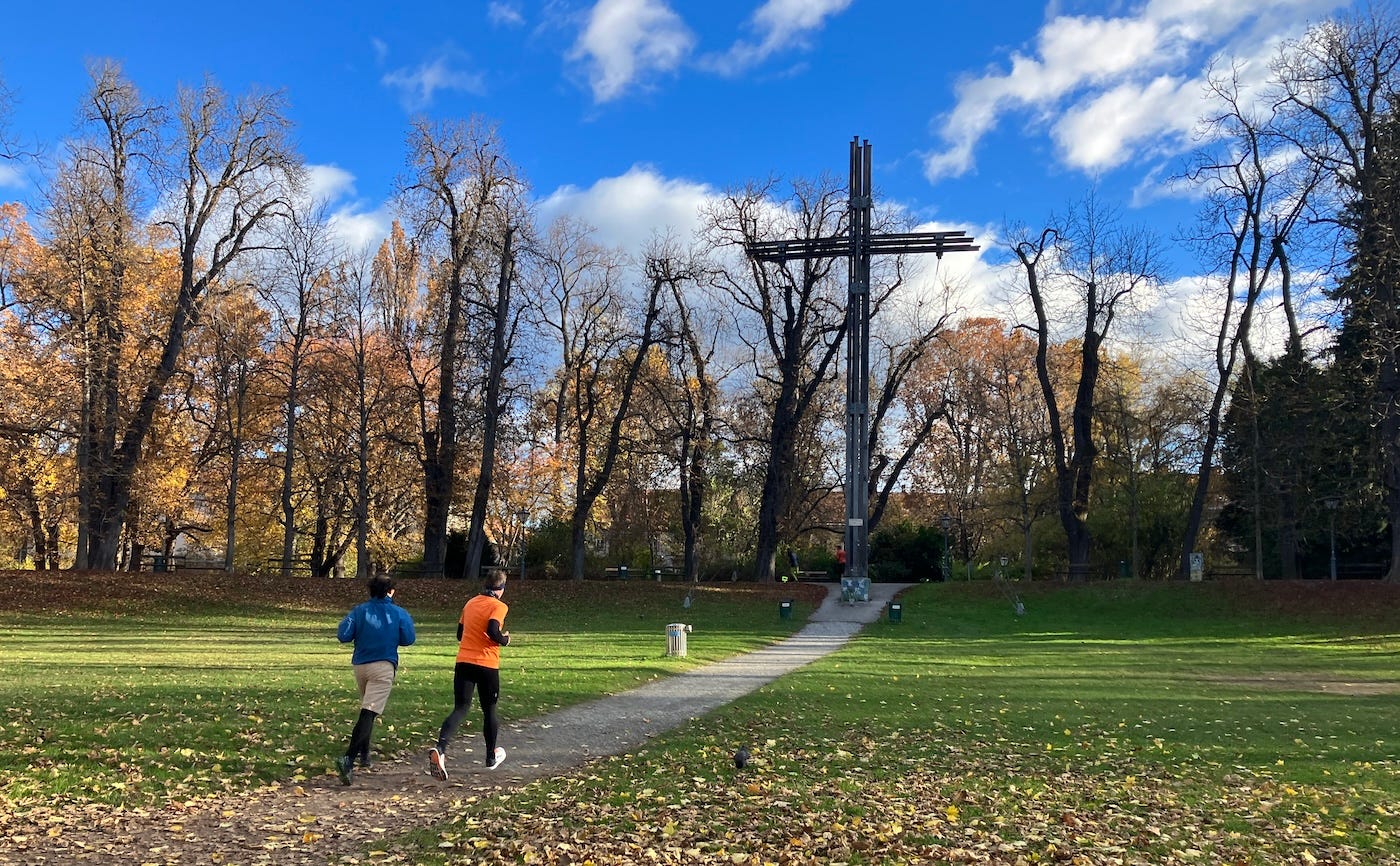 The cross stands over a field, with a slight slope before it