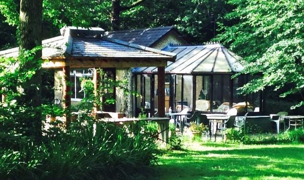 A glass-walled sunroom and wooden gazebo surrounded by trees and grass at the Valerian Sun Club on the Isle of Wight. Patio chairs and tables sit in the sunlight beside the building, which was later destroyed in the November 8 fire. A glass-walled sunroom and wooden gazebo surrounded by trees and grass at the Valerian Sun Club on the Isle of Wight. Patio chairs and tables sit in the sunlight beside the building, which was later destroyed in the November 8 fire.
