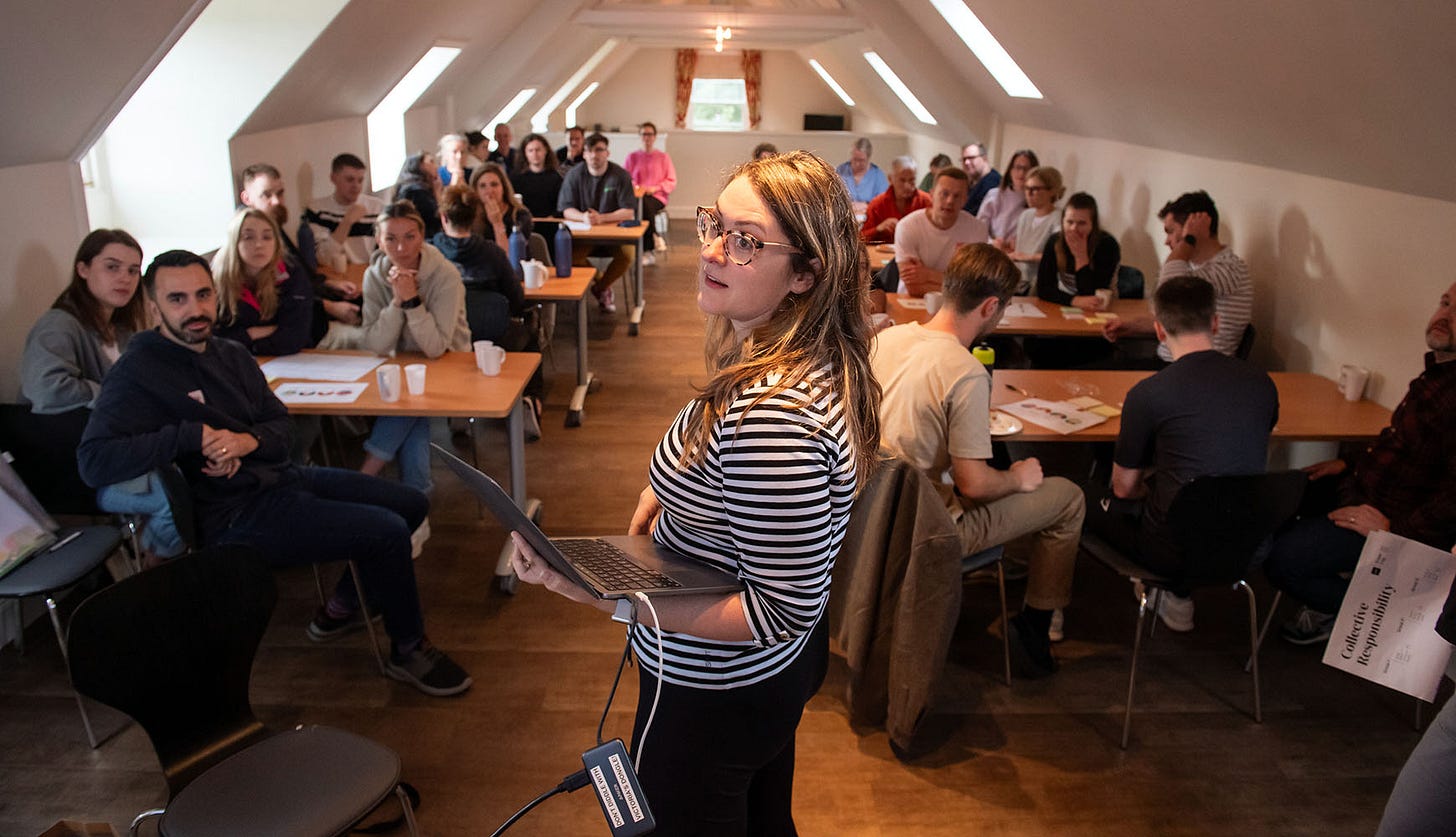 A professional-looking woman leads a session to a rapt group of Nile staff