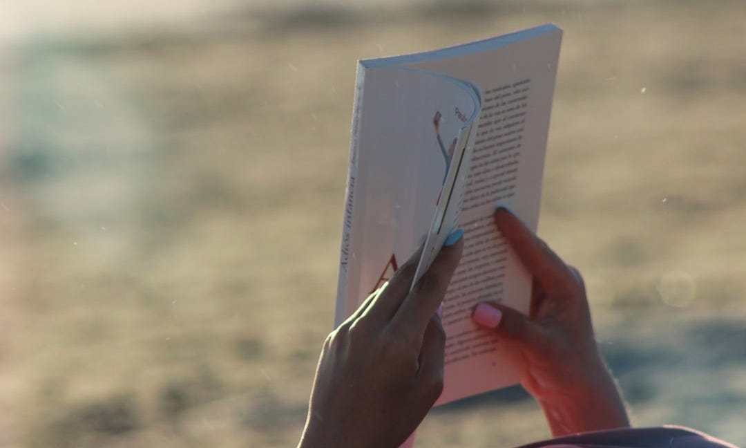 person holding white book during daytime