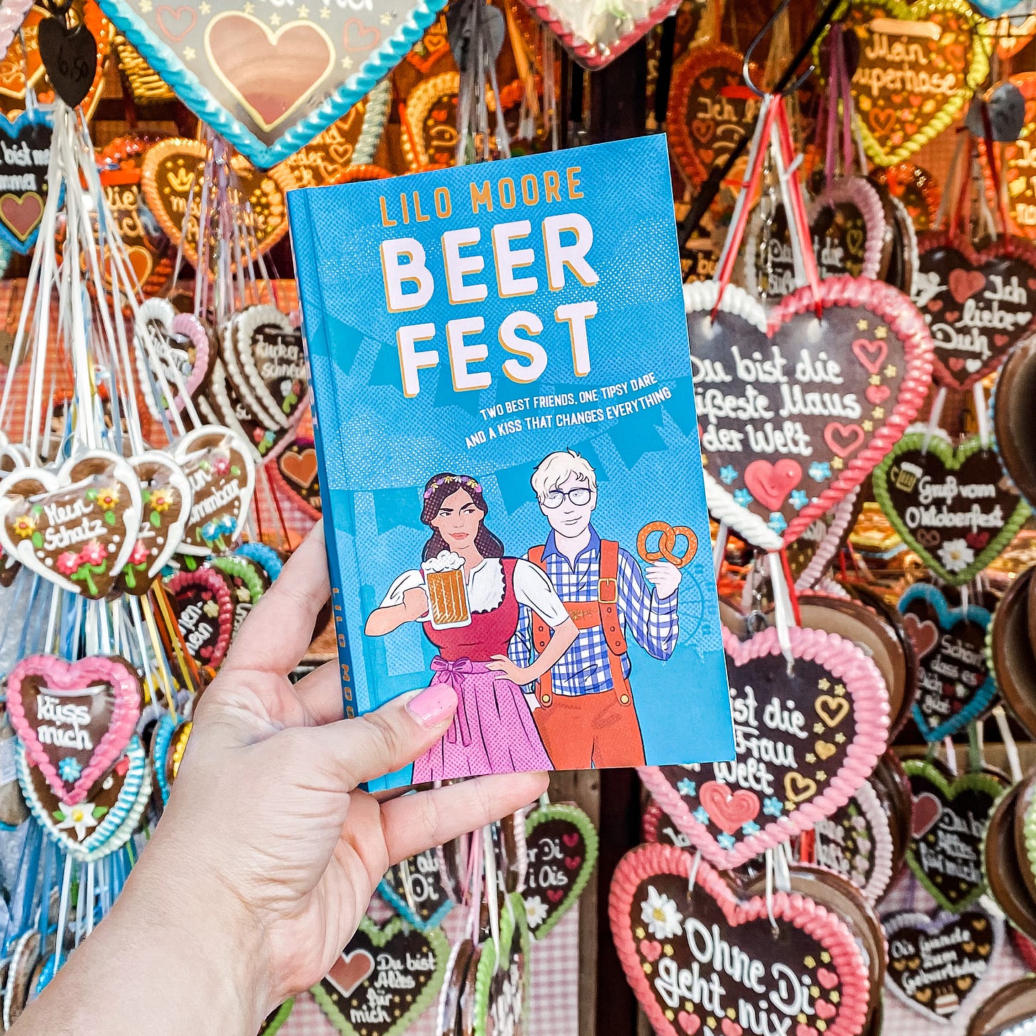 an image of the book cover of Beer Fest in front of gingerbread hearts at Oktoberfest