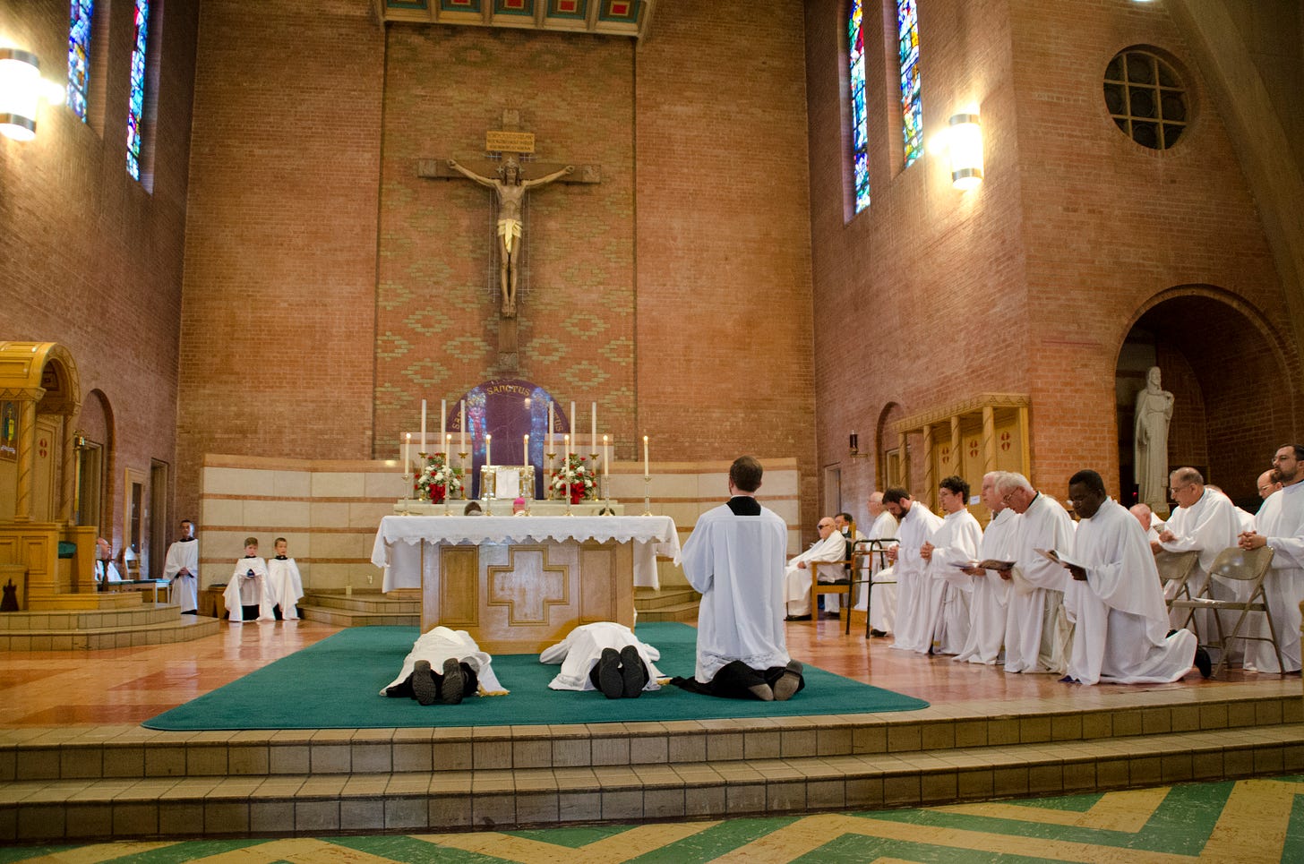 Both seminarians prostrate themselves before the altar. Fr. Nathanael Block, kneeling on the right side, was ordained just last year for the Diocese of Gallup.