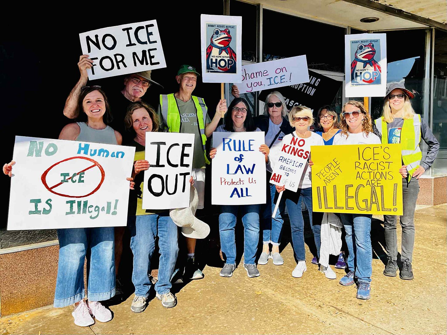 Several protestors hold up signs opposing ICE raids
