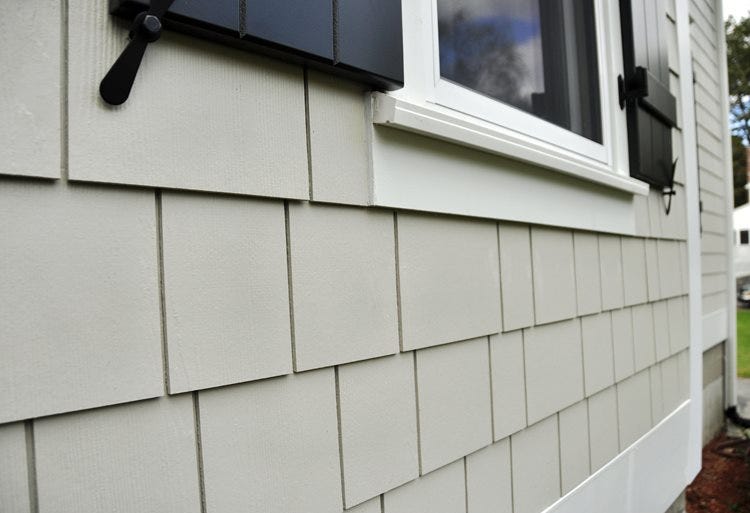 Side view of a house covered in white tiles of siding Side view of a house covered in white tiles of siding